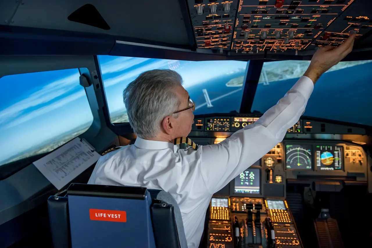 Pilot przy panelu górnym w symulatorze kabiny samolotu pasażerskiego